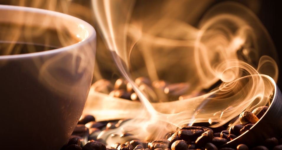 Dampende koffiebonen met een kopje koffie