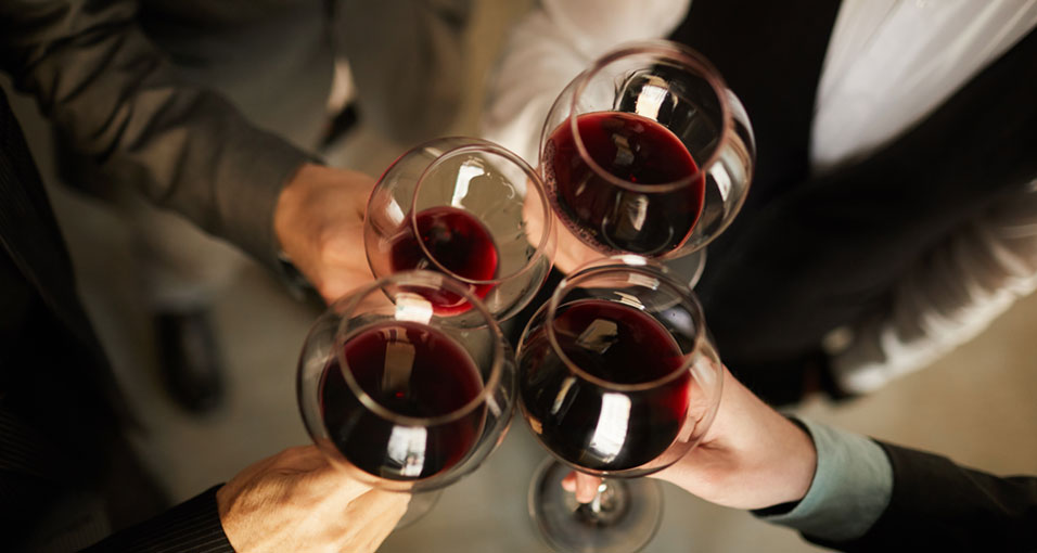 Glazen rode wijn die tegen elkaar worden getikt